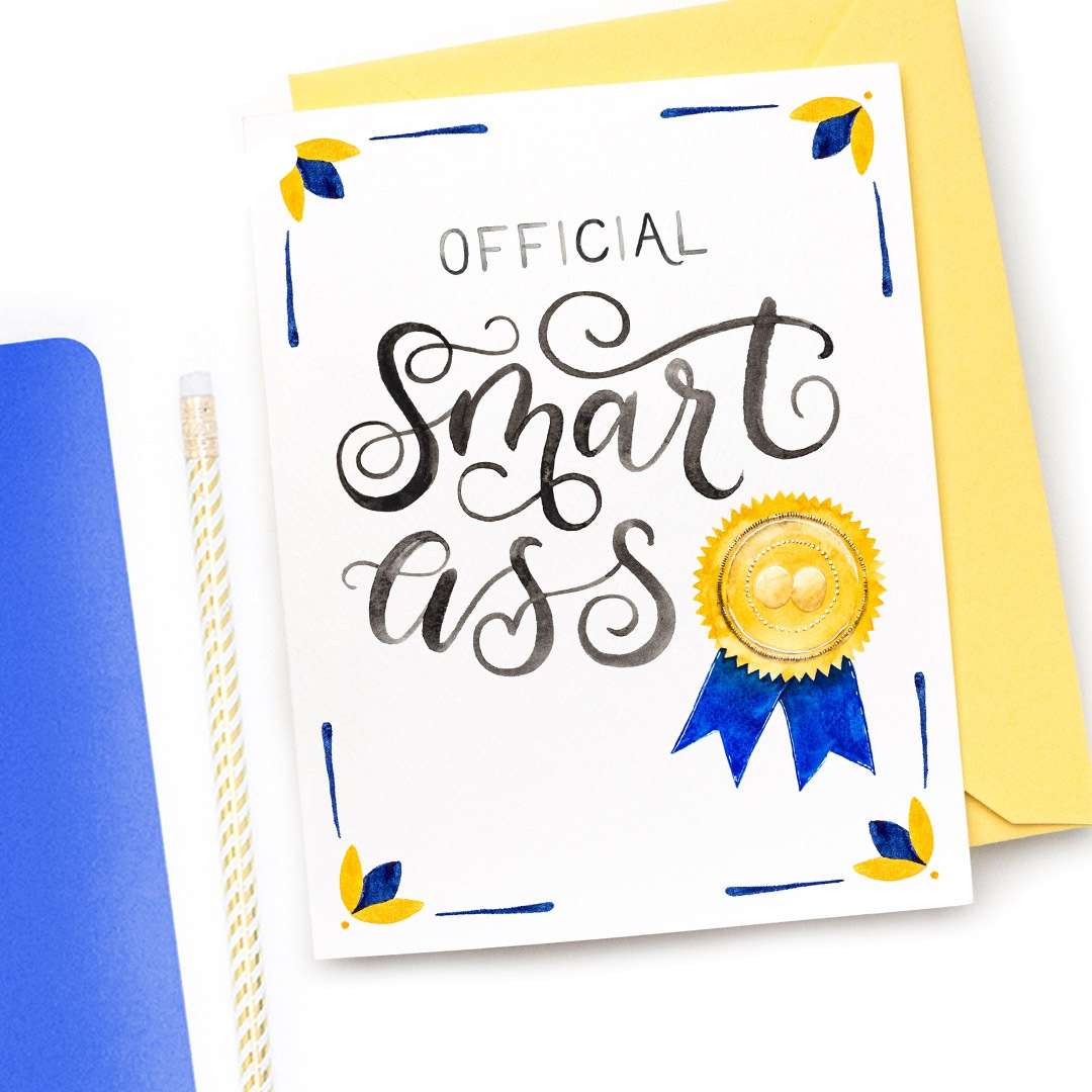 Image of a hand-lettered watercolor card saying "official smart ass" with a ribbon and gold seal by CharmCat | charmcat.net