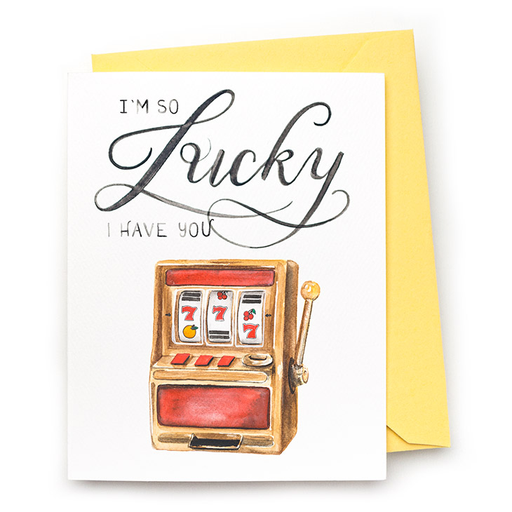 Image of a hand-lettered watercolor card saying "I'm so Lucky I have you" with a painting of a slot machine by CharmCat | charmcat.net