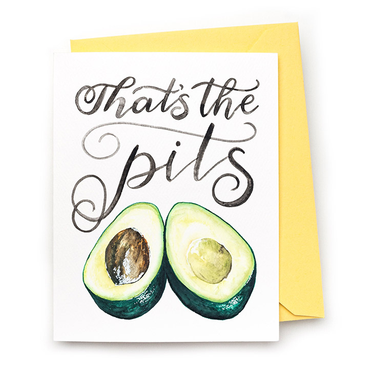 Image of a hand-lettered watercolor card saying "That's the pits" with an avocado in half by CharmCat | charmcat.net