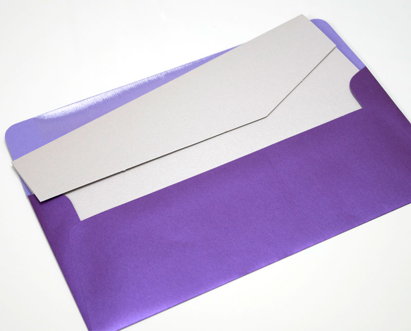 A number 10 size silver pocket in a dark purple envelope.